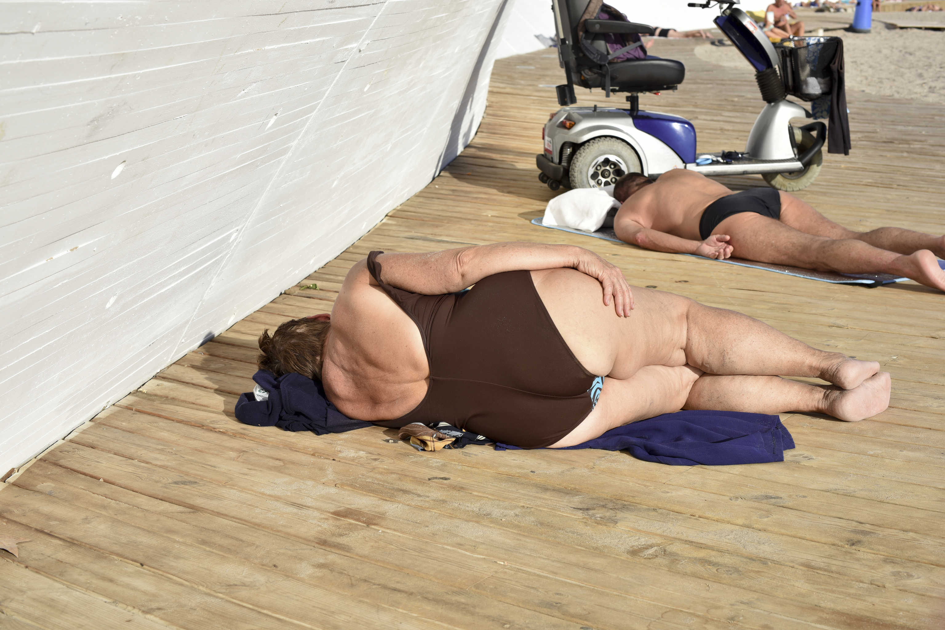 Dos personas dormidas en la playa de Levante de Benidorm.